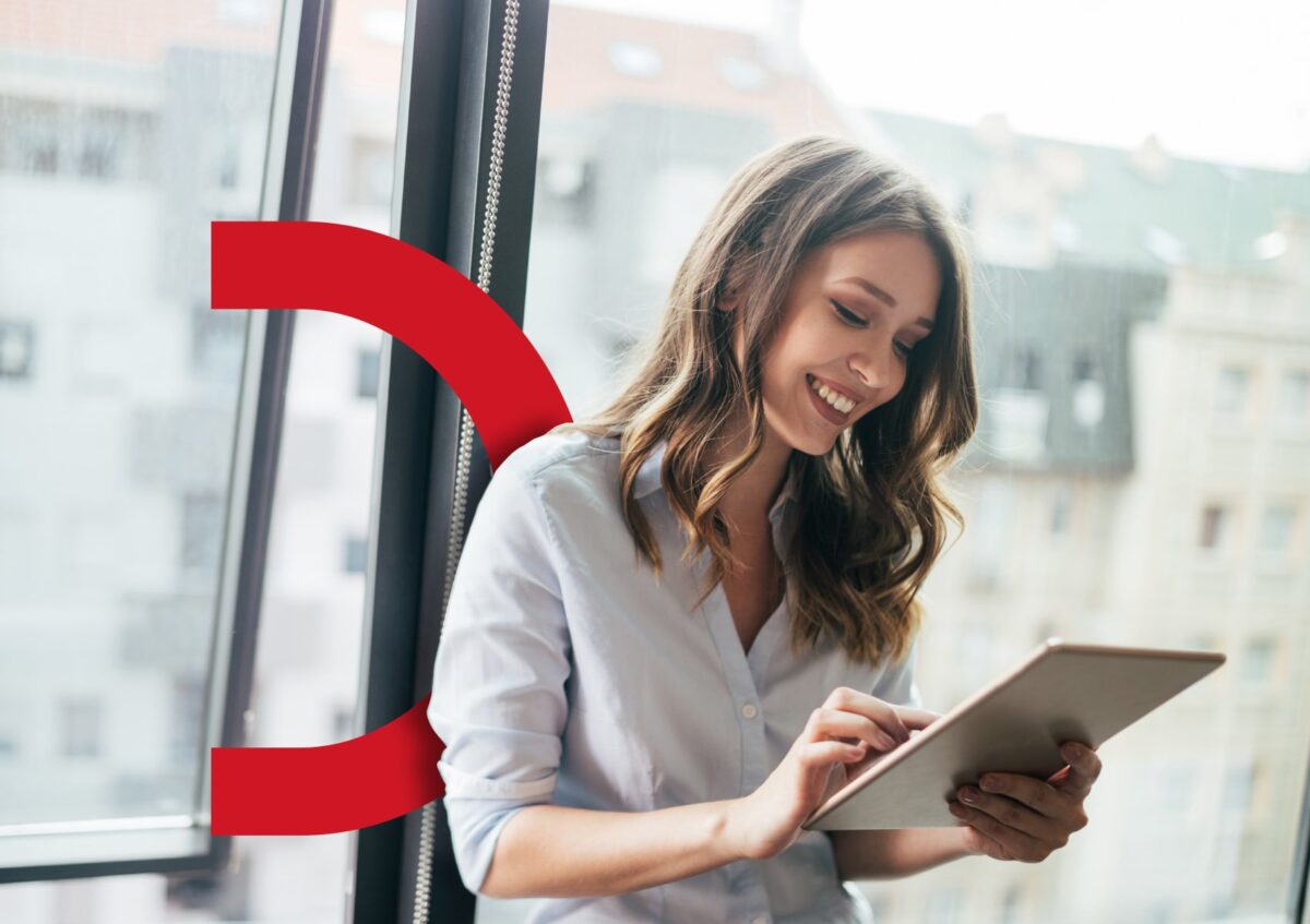 business woman smiling whilst using tablet
